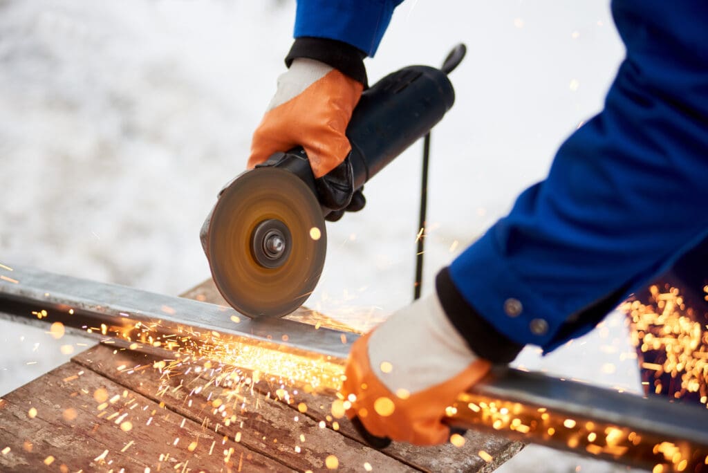 close up of an industrial worker cutting metal 
